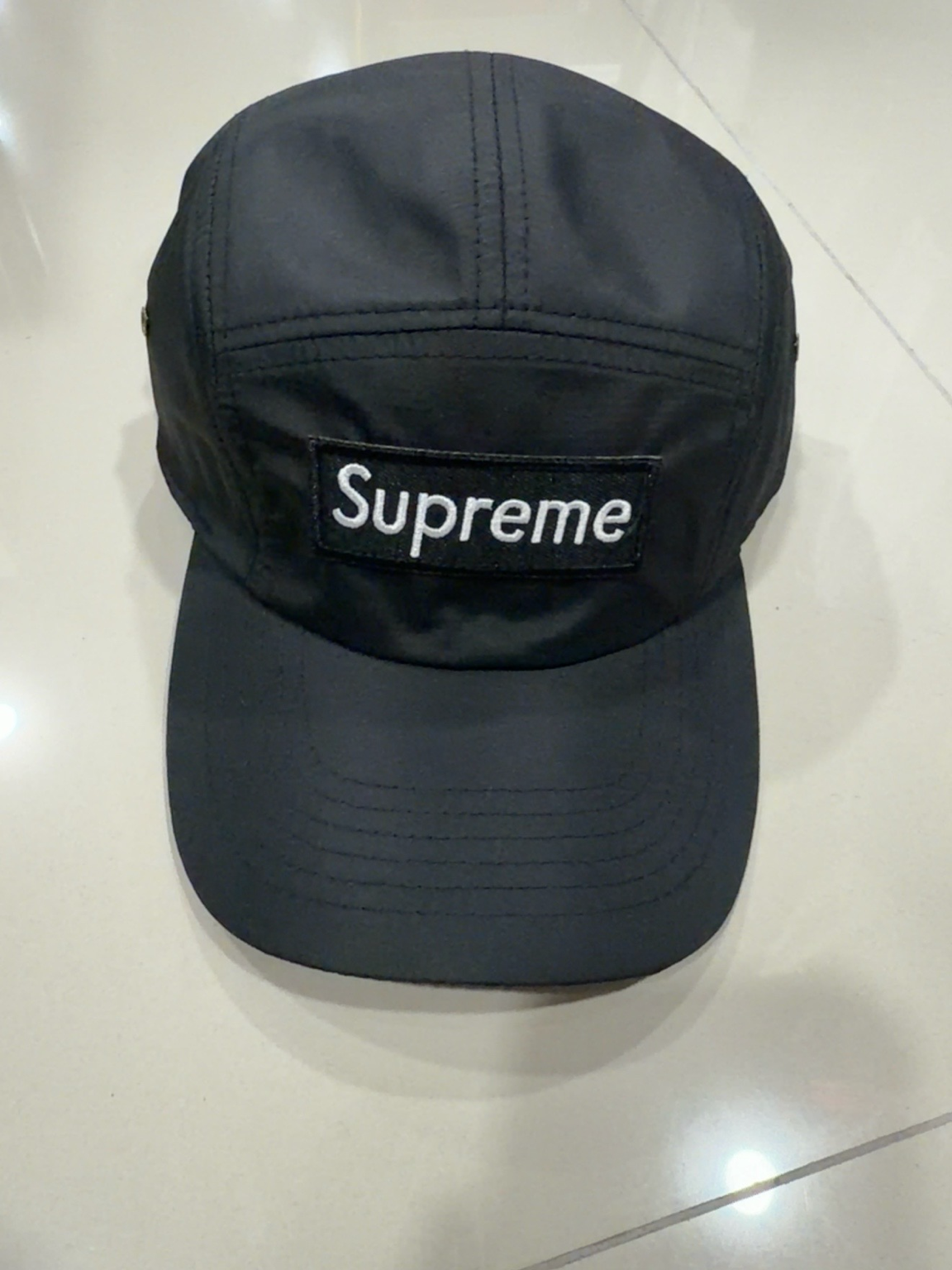 Supreme negra de cinco paneles con parche negro y letras blancas
