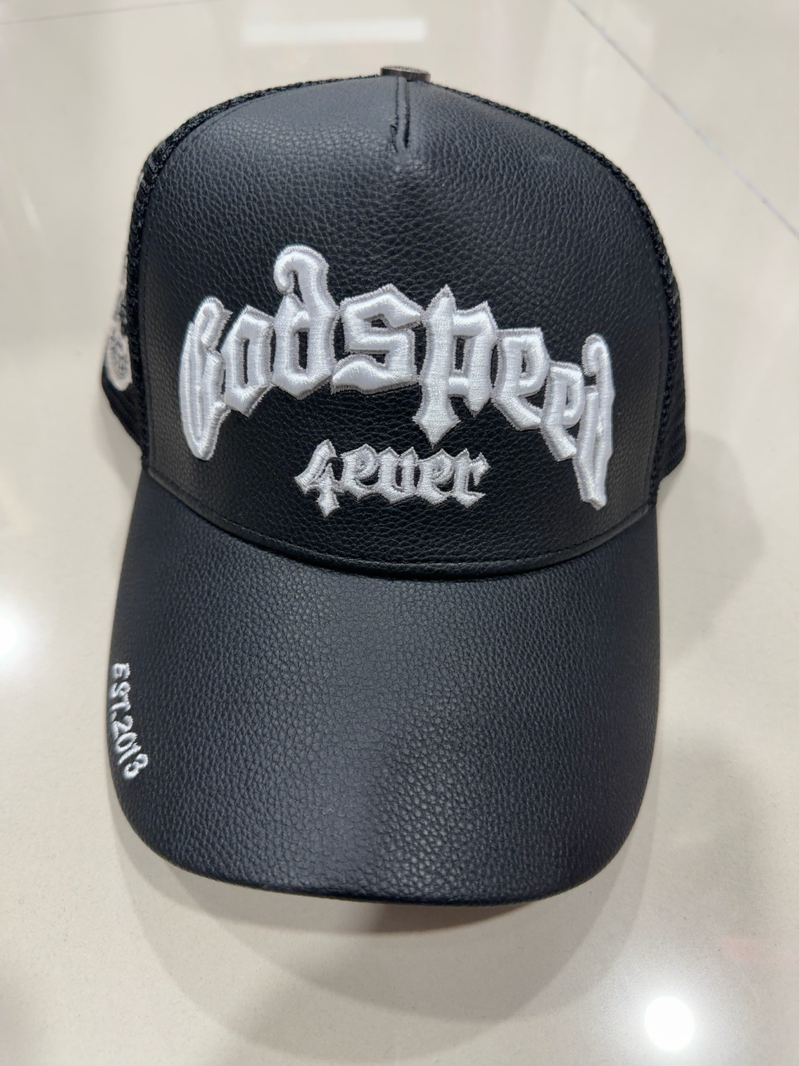Godspeed Cuero negra con frente de textura tipo cuero y bordado blanco